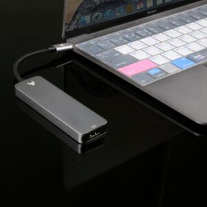 A sleek USB hub connected to a modern laptop on a reflective surface.
